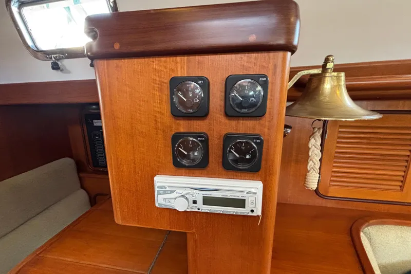Slide: The Image of Wooden control panel with gauges and stereo on a 2002 Passport 470 Center Cockpit yacht. - 52