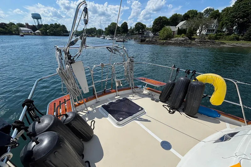 Slide: The Image of Deck view of 2002 Passport 470 Center Cockpit sailboat, docked near lush shoreline. - 15