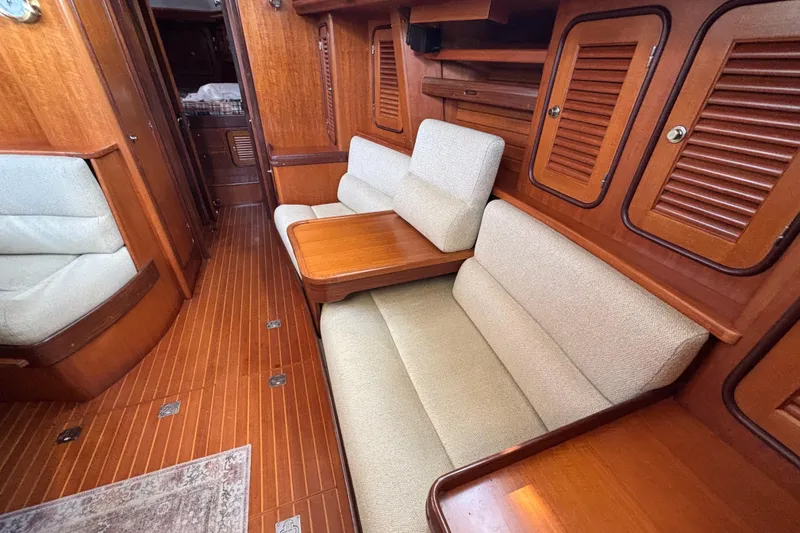 Slide: The Image of Luxurious interior of a 2002 Passport 470 Center Cockpit yacht with wooden finishes and cushioned seating. - 44