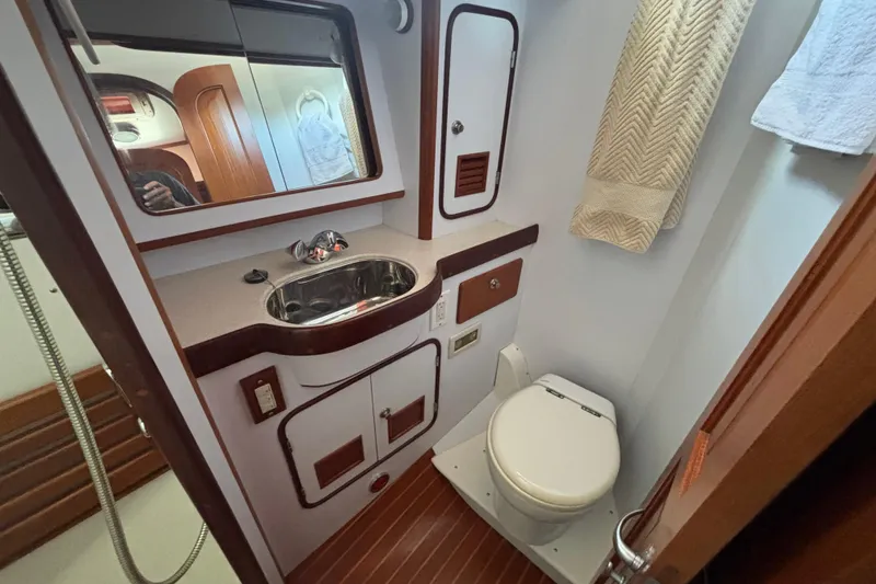 Slide: The Image of Bathroom interior of 2002 Passport 470 Center Cockpit yacht, featuring sink and toilet. - 76