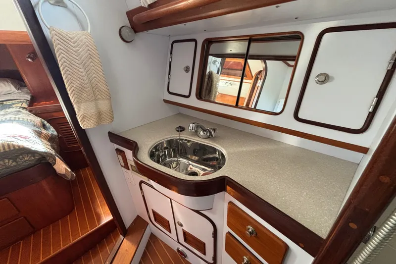 Slide: The Image of Luxurious 2002 Passport 470 Center Cockpit yacht interior with sink and wooden cabinetry. - 67