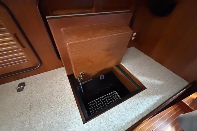 Slide: The Image of Interior view of 2002 Passport 470 Center Cockpit yacht, featuring a wooden storage compartment. - 57