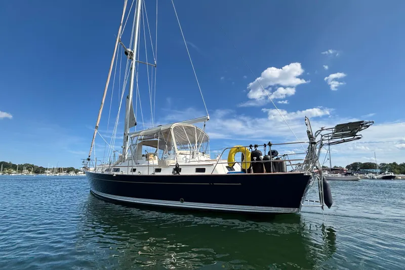 Slide: The Image of 2002 Passport 470 Center Cockpit sailboat on calm water under blue sky. - 6