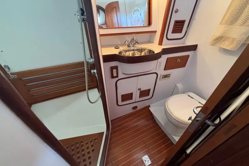 Slide: The Image of Bathroom interior of 2002 Passport 470 Center Cockpit yacht, featuring shower, sink, and toilet. - 78