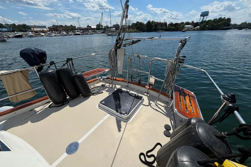 Slide: The Image of 2002 Passport 470 Center Cockpit sailboat deck with marina view and clear skies. - 16