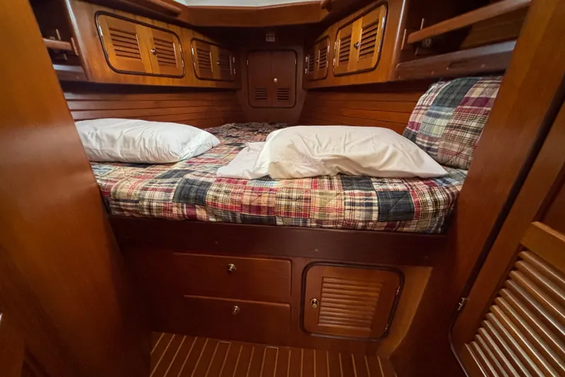 Slide: The Image of Cozy cabin interior of 2002 Passport 470 Center Cockpit sailboat with plaid bedding. - 73