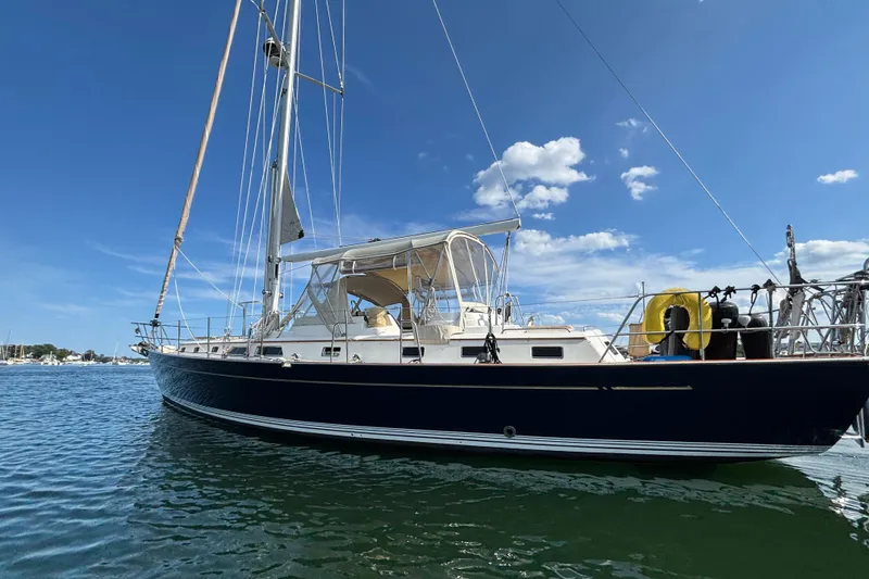Slide: The Image of Sailing yacht Passport 470 Center Cockpit, 2002 model, anchored on calm waters under blue sky. - 2