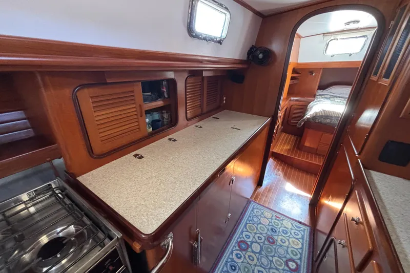Slide: The Image of Interior of 2002 Passport 470 Center Cockpit yacht with wood cabinetry and cozy sleeping area. - 62