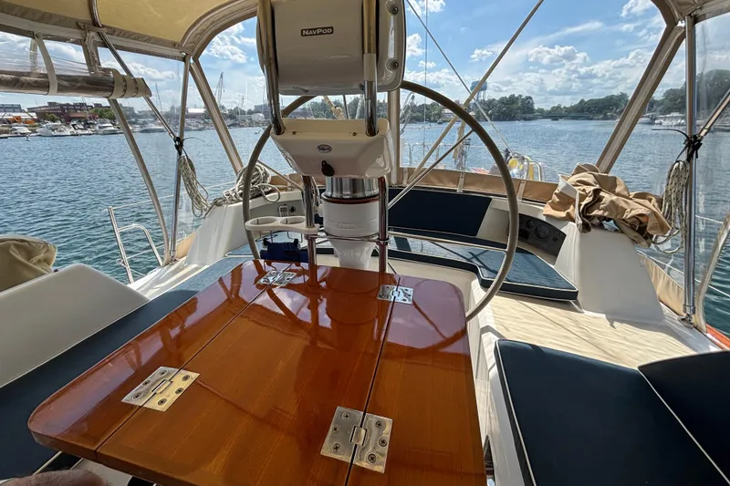 Slide: The Image of Cockpit view of 2002 Passport 470 Center Cockpit sailboat with wooden table and steering wheel. - 23