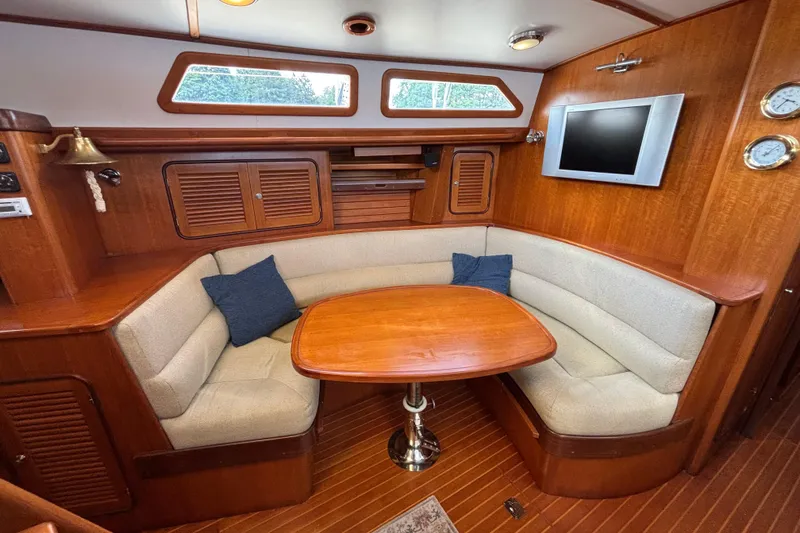 Slide: The Image of Cozy interior of 2002 Passport 470 Center Cockpit with wood finish and cushioned seating. - 41