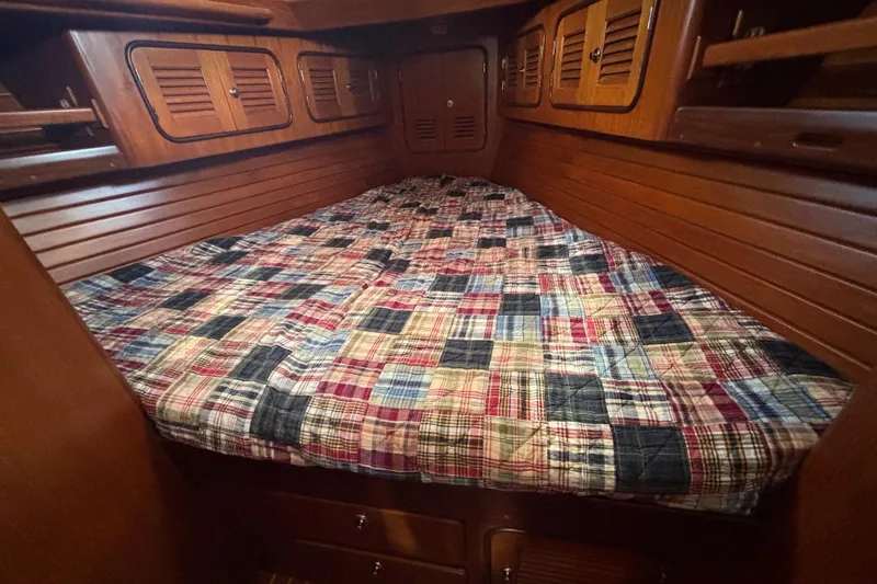 Slide: The Image of Cozy cabin interior of 2002 Passport 470 Center Cockpit with plaid bedding and wooden finish. - 72
