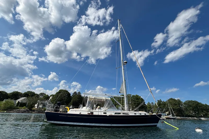 Slide: The Image of Sailboat "Passport 470 Center Cockpit" 2002 model on calm water under blue sky. - 8