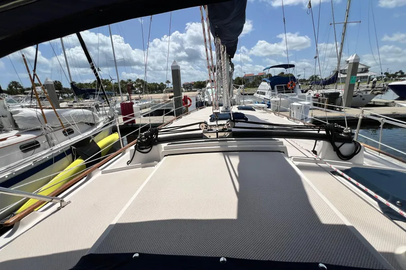 Slide: The Image of 1987 Island Packet SP Cruiser sailboat docked at a marina under a sunny sky. - 9