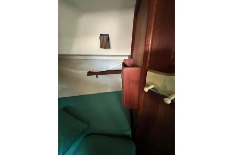 Slide: The Image of Cozy cabin interior of 1987 Island Packet SP Cruiser with wooden accents and green bedding. - 73