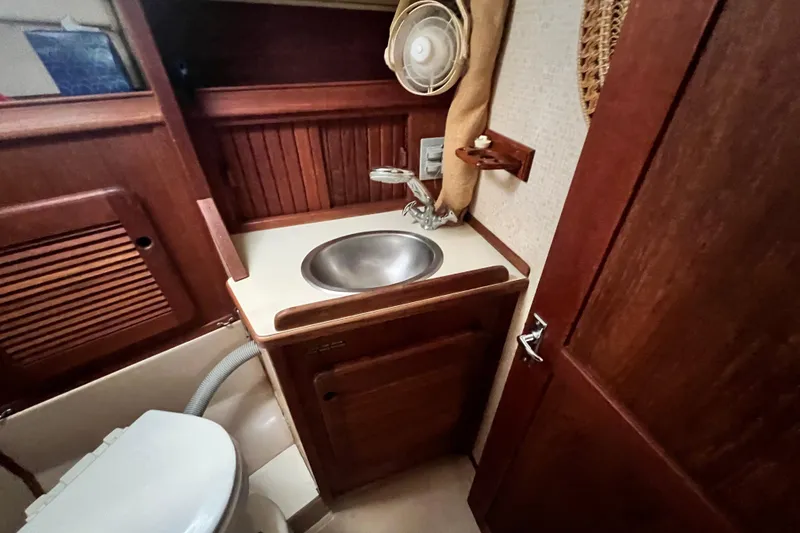 Slide: The Image of 1987 Island Packet SP Cruiser bathroom with wooden cabinetry and stainless steel sink. - 69