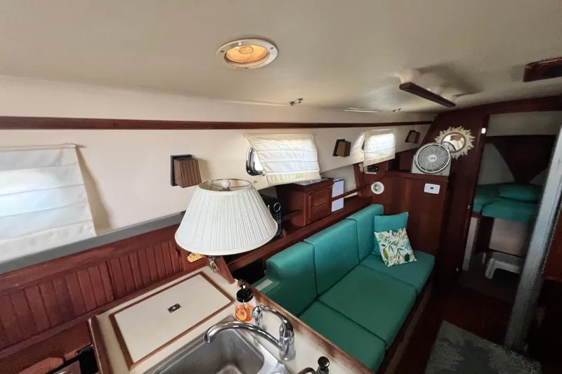 Slide: The Image of Interior of 1987 Island Packet SP Cruiser with teal seating, wooden accents, and cozy decor. - 58