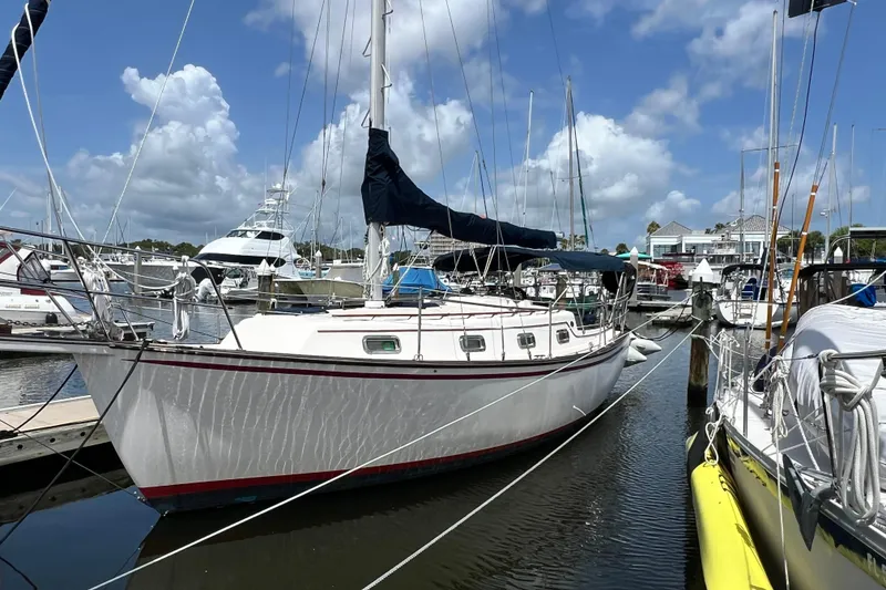 The Image of 1987 Island Packet SP Cruiser sailboat docked at marina under blue sky. - 0