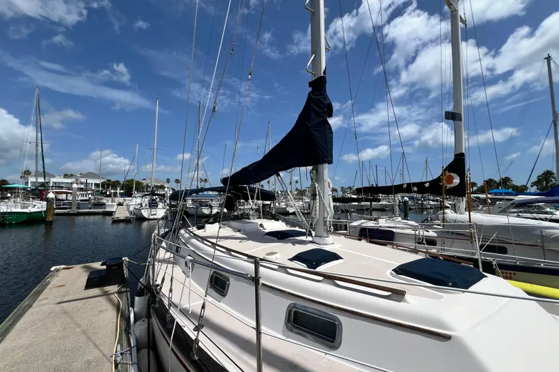Slide: The Image of 1987 Island Packet SP Cruiser docked at a marina under a clear blue sky. - 2