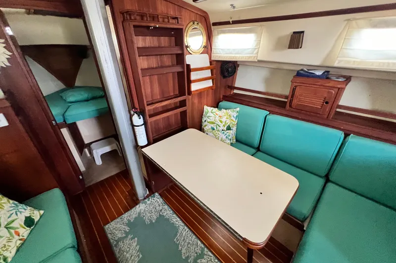 Slide: The Image of Interior of 1987 Island Packet SP Cruiser with teal seating and wooden accents. - 64