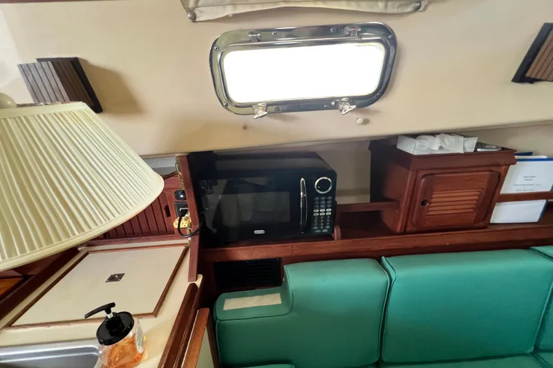 Slide: The Image of Interior of 1987 Island Packet SP Cruiser with microwave, lamp, and green seating. - 62