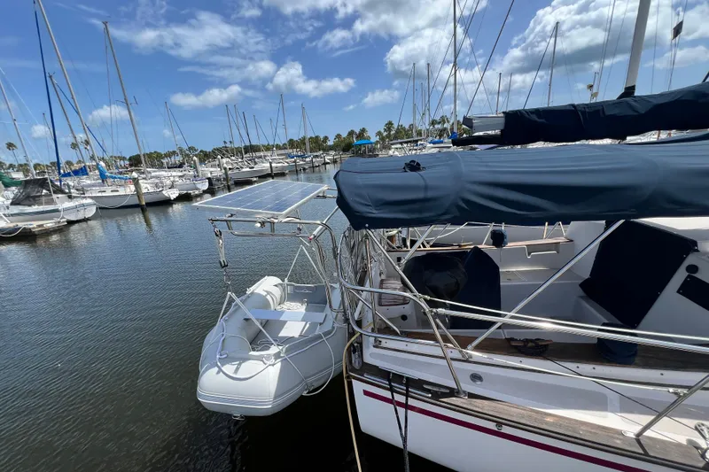 Slide: The Image of 1987 Island Packet SP Cruiser docked with inflatable dinghy and solar panels. - 7
