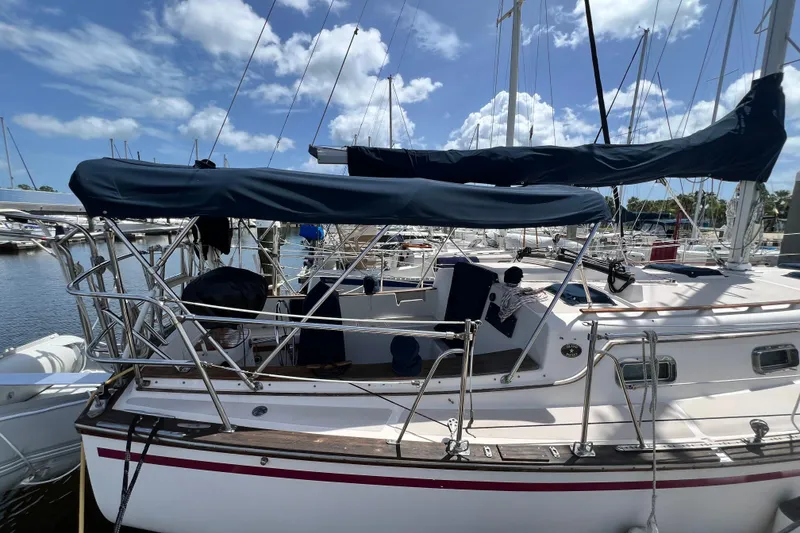 Slide: The Image of 1987 Island Packet SP Cruiser sailboat docked at marina under clear blue sky. - 3