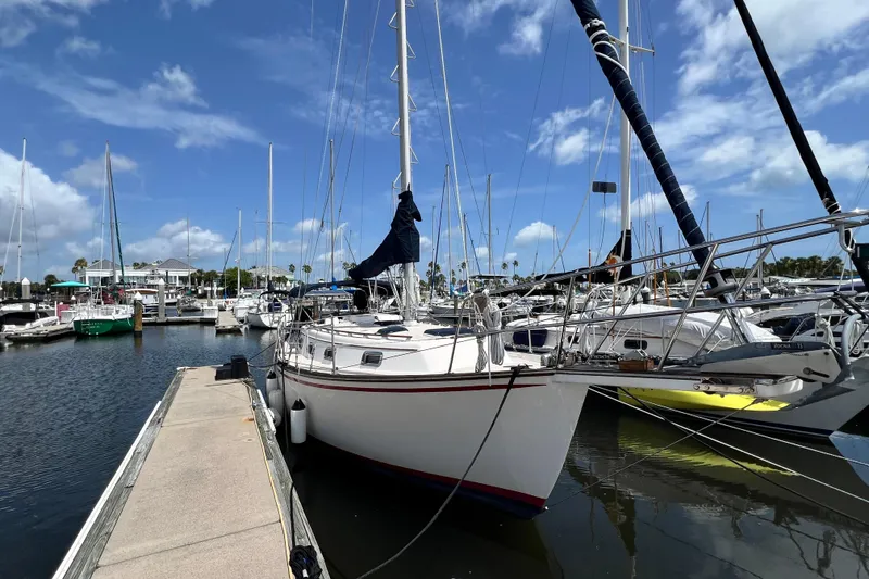 Slide: The Image of 1987 Island Packet SP Cruiser docked at a marina under a clear blue sky. - 1