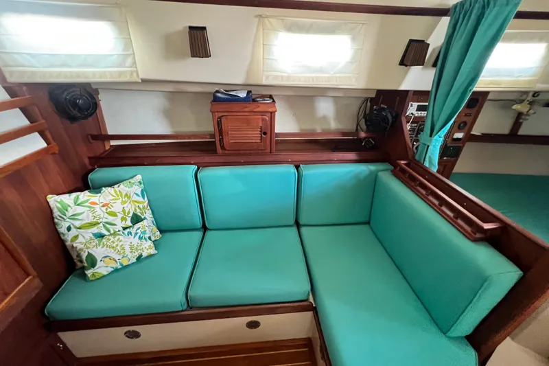 Slide: The Image of Cozy interior of 1987 Island Packet SP Cruiser with teal cushions and floral pillow. - 63