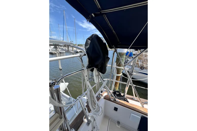 Slide: The Image of 1987 Island Packet SP Cruiser sailboat deck with ropes and marina view. - 20