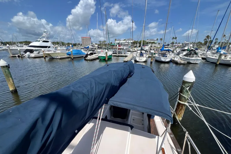Slide: The Image of 1987 Island Packet SP Cruiser docked in a marina with sailboats and yachts. - 17