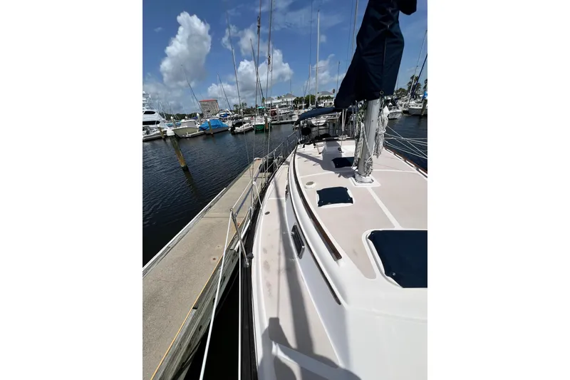Slide: The Image of 1987 Island Packet SP Cruiser docked at marina under blue sky. - 12