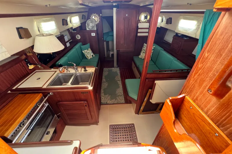 Slide: The Image of Interior of 1987 Island Packet SP Cruiser with wood finish and teal seating. - 43