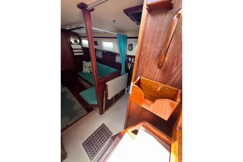 Slide: The Image of Interior of 1987 Island Packet SP Cruiser with wooden finish and teal seating. - 45