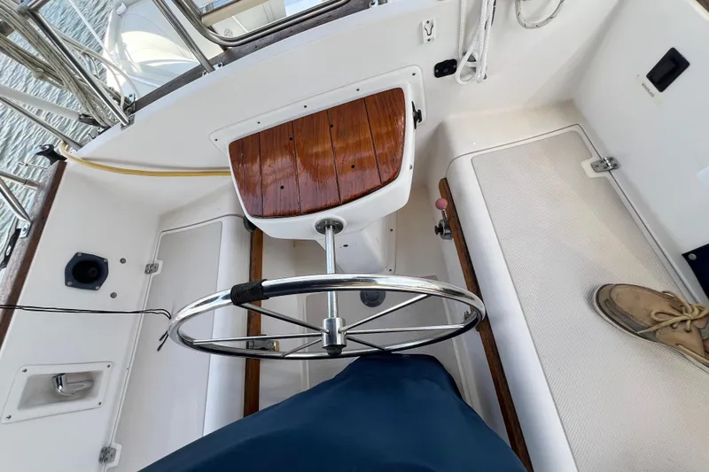 Slide: The Image of Cockpit of 1987 Island Packet SP Cruiser with steering wheel and wooden accents. - 23