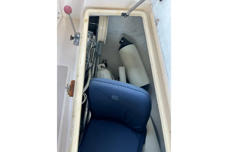 Slide: The Image of Storage compartment of 1987 Island Packet SP Cruiser with marine equipment and blue cushion. - 37