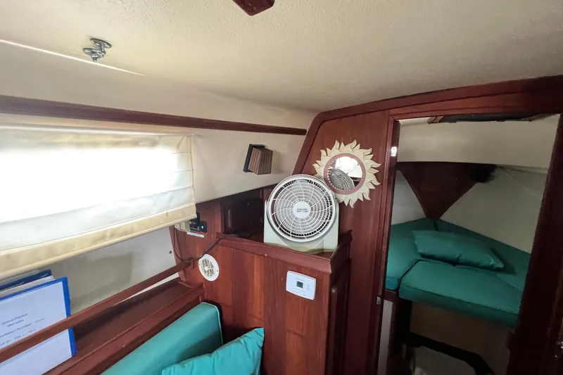 Slide: The Image of Interior of 1987 Island Packet SP Cruiser with fan, sun mirror, and teal bedding. - 60