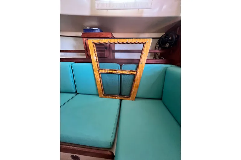 Slide: The Image of Interior of 1987 Island Packet SP Cruiser with teal seating and wooden frame detail. - 42