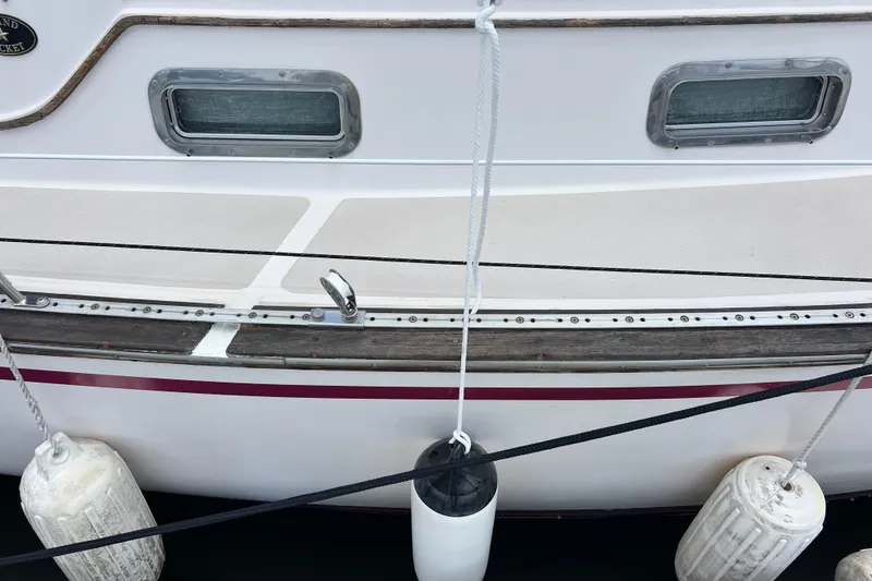 Slide: The Image of Side view of 1987 Island Packet SP Cruiser with fenders and portholes. - 5