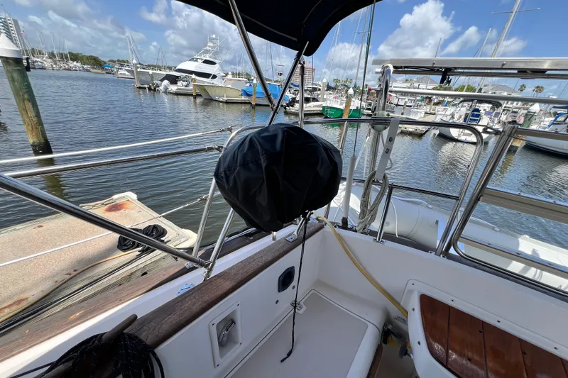 Slide: The Image of 1987 Island Packet SP Cruiser docked at marina, featuring deck and railing view. - 19