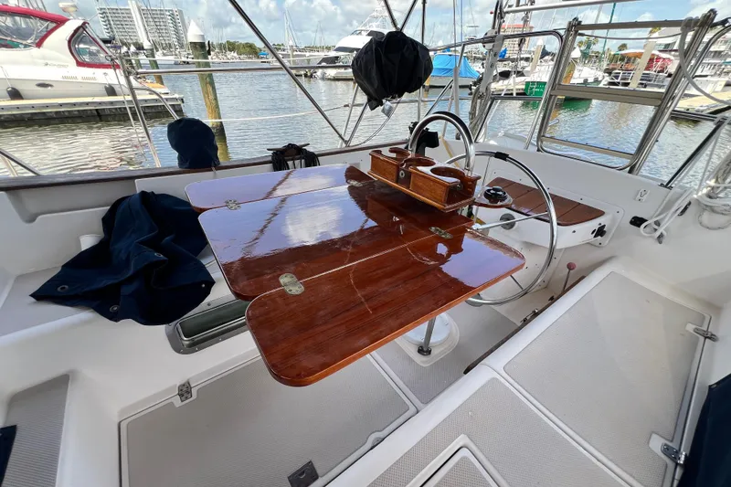 Slide: The Image of Cockpit of 1987 Island Packet SP Cruiser with polished wooden table and steering wheel. - 40