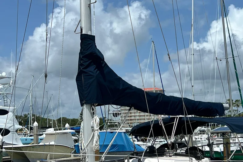Slide: The Image of Sailboat mast and boom of 1987 Island Packet SP Cruiser docked at marina under cloudy sky. - 14