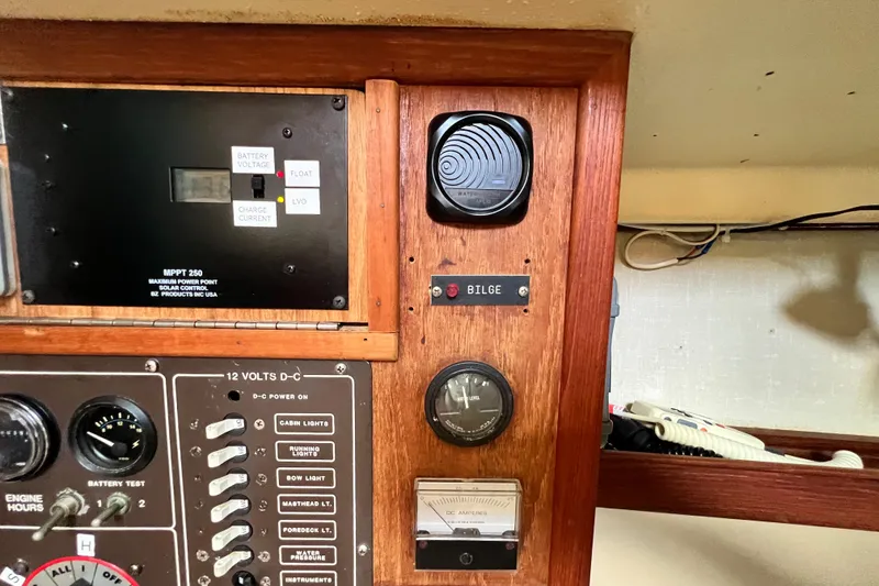 Slide: The Image of Control panel of a 1987 Island Packet SP Cruiser with various gauges and switches. - 52