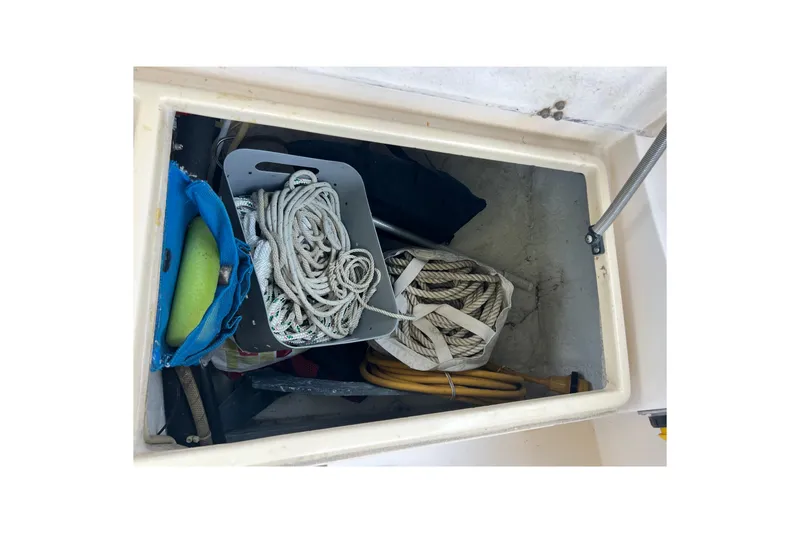 Slide: The Image of Storage compartment on 1987 Island Packet SP Cruiser with ropes and boating equipment. - 35