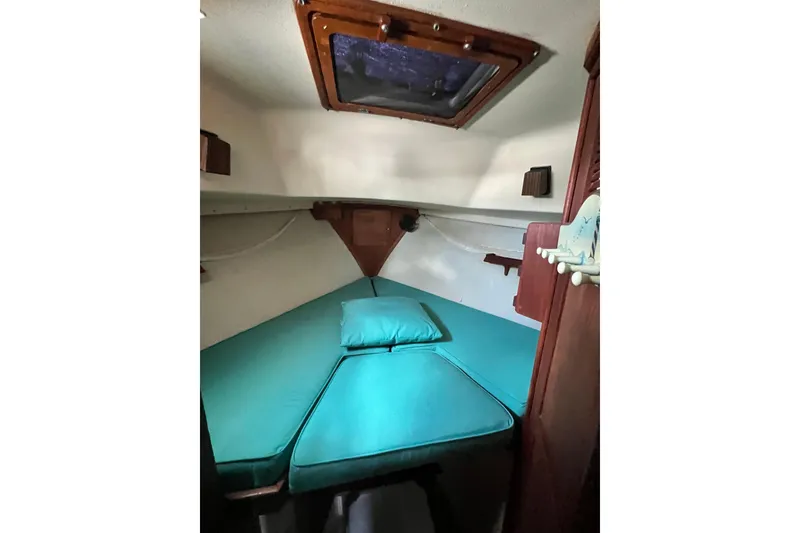 Slide: The Image of Cozy cabin interior of 1987 Island Packet SP Cruiser with teal bedding and wooden accents. - 70