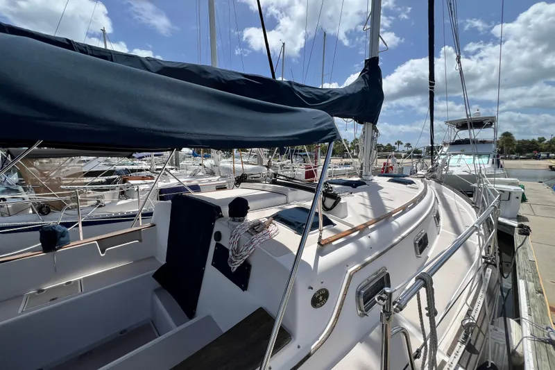 Slide: The Image of 1987 Island Packet SP Cruiser docked at marina under blue sky. - 4