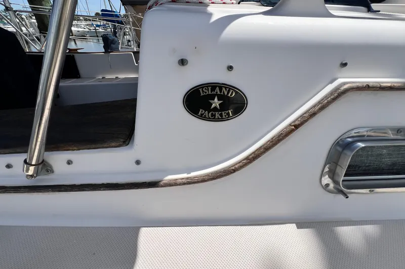 Slide: The Image of 1987 Island Packet SP Cruiser boat detail with logo and railing in marina setting. - 6