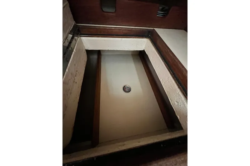 Slide: The Image of Interior compartment of 1987 Island Packet SP Cruiser sailboat, featuring wooden trim and storage space. - 57