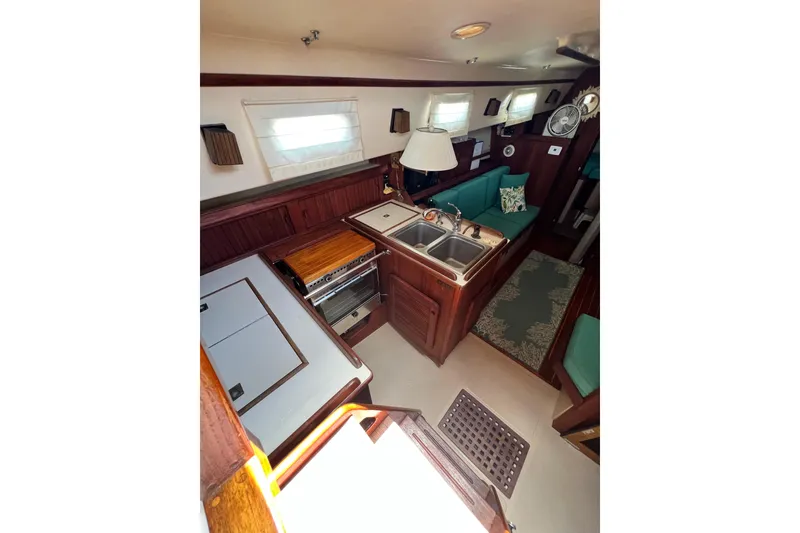 Slide: The Image of 1987 Island Packet SP Cruiser interior with kitchen, sink, stove, and seating area. - 44