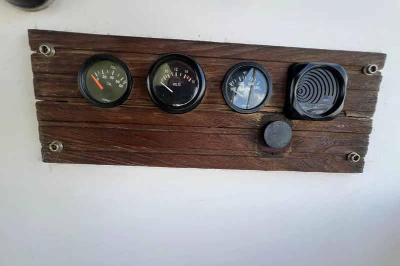 Slide: The Image of Wooden panel with gauges for oil, volts, and water temperature on a 1987 Island Packet SP Cruiser. - 28
