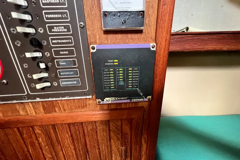 Slide: The Image of Electrical panel on a 1987 Island Packet SP Cruiser sailboat, featuring switches and voltage indicators. - 51